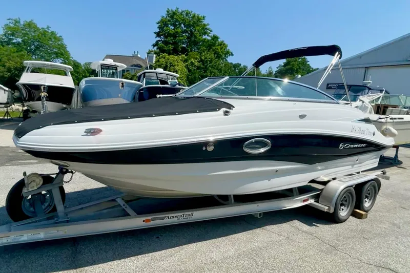 Slide: The Image of 2015 Crownline Eclipse E2 XS boat on trailer, parked outdoors with other boats. - 2
