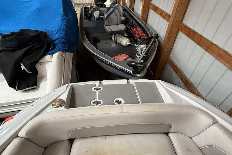 Slide: The Image of 2015 Crownline Eclipse E2 XS boat stored in a wooden shed with another boat. - 20