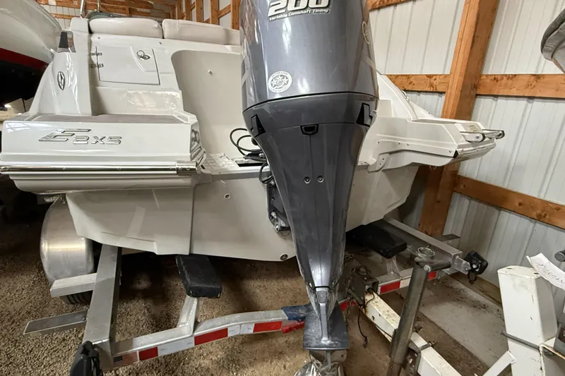 Slide: The Image of 2015 Crownline Eclipse E2 XS boat with outboard motor in storage. - 25