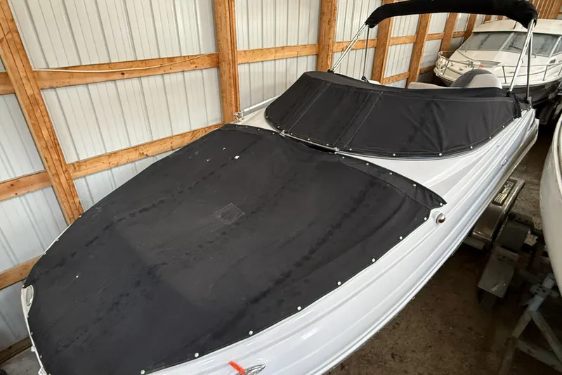 Slide: The Image of 2015 Crownline Eclipse E2 XS boat with black cover in storage. - 27