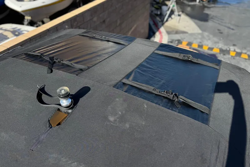 Slide: The Image of ATX 22 TYPE S 2020 boat cover with straps and vent, parked outdoors. - 16