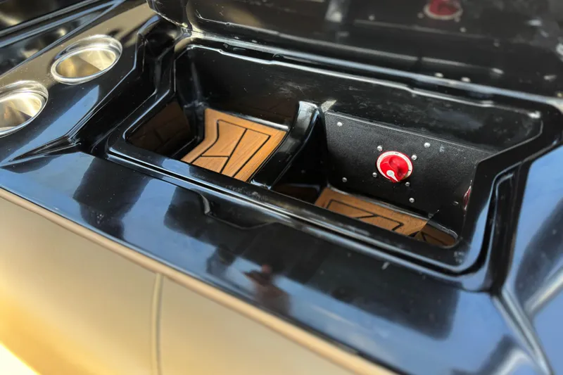 Slide: The Image of Open storage compartment in a 2020 ATX 22 TYPE S boat with cup holders. - 26