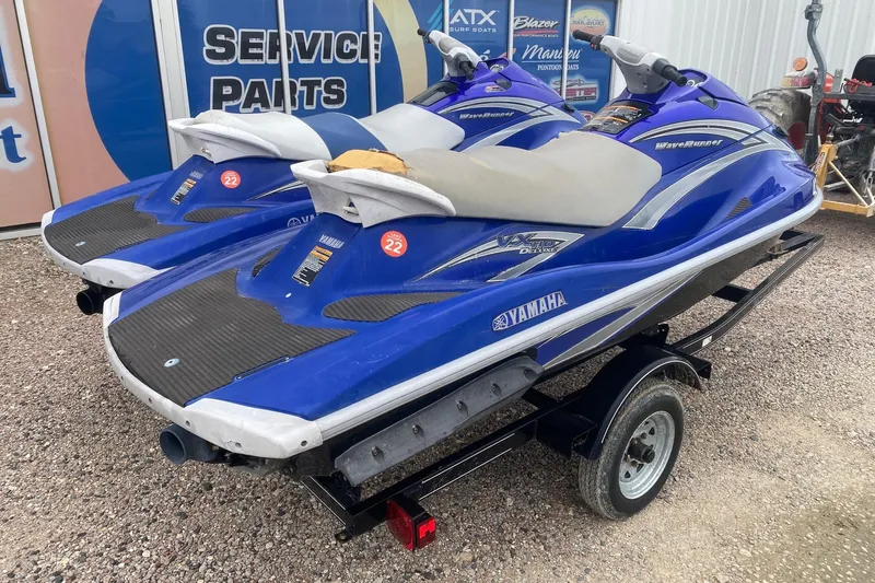 Slide: The Image of 2006 Yamaha WaveRunner VX Cruiser jet skis on a trailer, parked outdoors. - 5