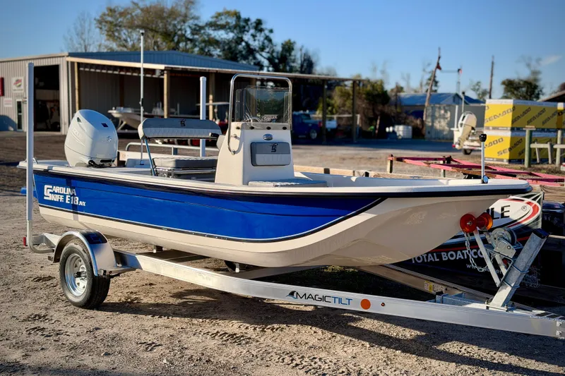 The Image of 2026 Carolina Skiff E18 JVX CC boat on trailer, parked outdoors. - 0