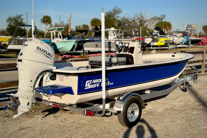 Slide: The Image of 2026 Carolina Skiff E18 JVX CC boat with Suzuki engine on trailer. - 17