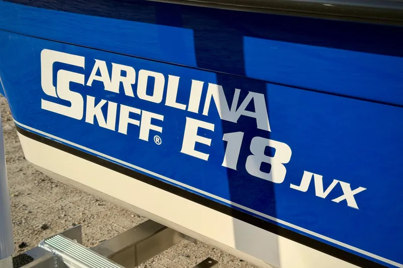 Slide: The Image of 2026 Carolina Skiff E18 JVX CC boat logo on blue hull. - 6