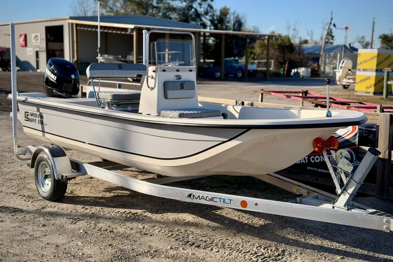 The Image of 2026 Carolina Skiff E18 JVX CC boat on trailer, parked outdoors. - 0