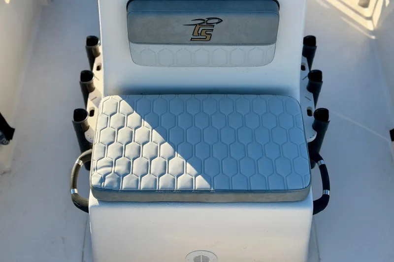 Slide: The Image of 2026 Carolina Skiff E18 JVX CC boat seat with hexagonal pattern and rod holders. - 13