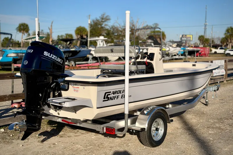 Slide: The Image of 2026 Carolina Skiff E18 JVX CC boat with Suzuki engine on trailer. - 17