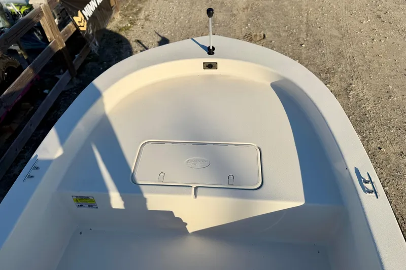 Slide: The Image of 2026 Carolina Skiff E18 JVX CC boat interior, featuring storage compartment and clean deck design. - 9