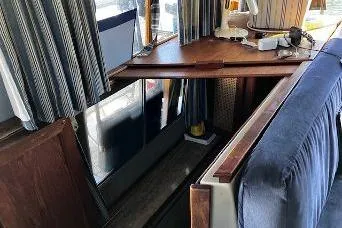 Slide: The Image of 1985 Bayliner 3270 Motoryacht interior with wooden cover for lower cabin and blue upholstery. - 5