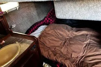 Slide: The Image of Cozy cabin interior of 1985 Bayliner 3270 Motoryacht with queen bed and sink. - 7