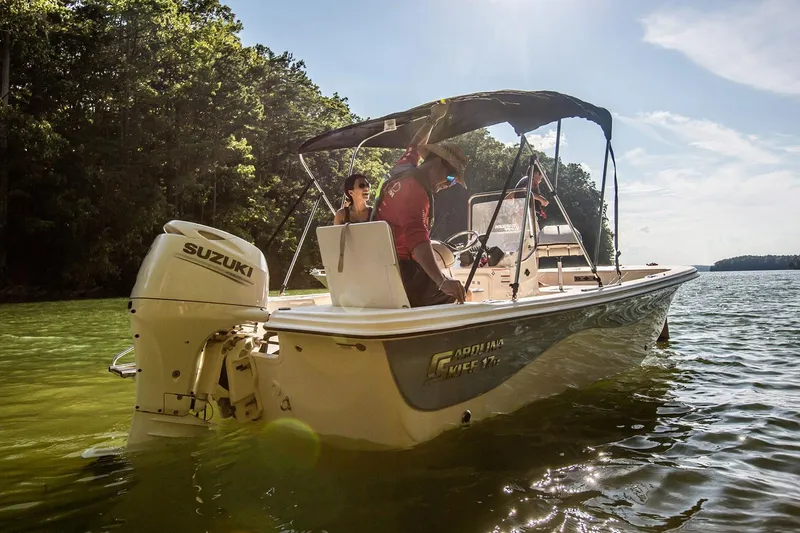 Slide: The Image of Manufacturer Provided Image: 2025 Carolina Skiff 17 LS boat on a sunny lake with Suzuki outboard motor. - 18