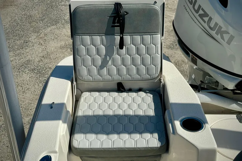 Slide: The Image of 2025 Carolina Skiff 17 LS boat seat with hexagonal pattern, next to Suzuki outboard motor. - 7