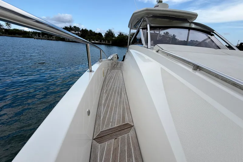 Slide: The Image of 2014 Azimut Verve 40 yacht on calm water, showcasing sleek design and wooden deck. - 18