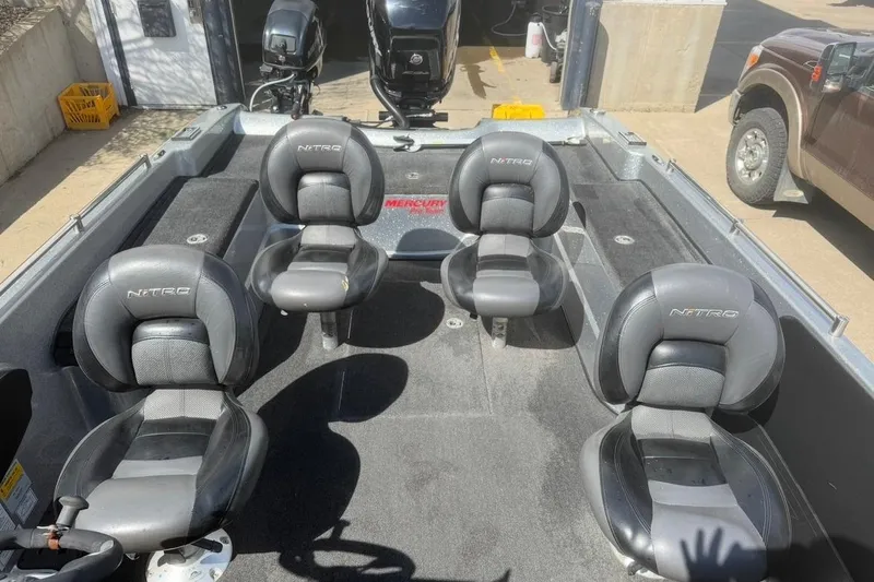 Slide: The Image of 2015 Nitro ZV21 boat interior with four black seats and Mercury engine. - 14