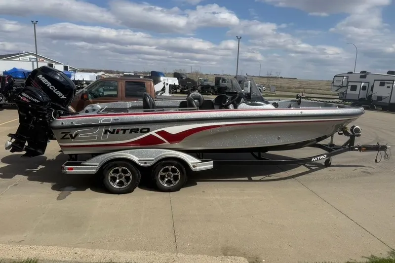 Slide: The Image of 2015 Nitro ZV21 boat on trailer, parked outdoors under cloudy sky. - 6