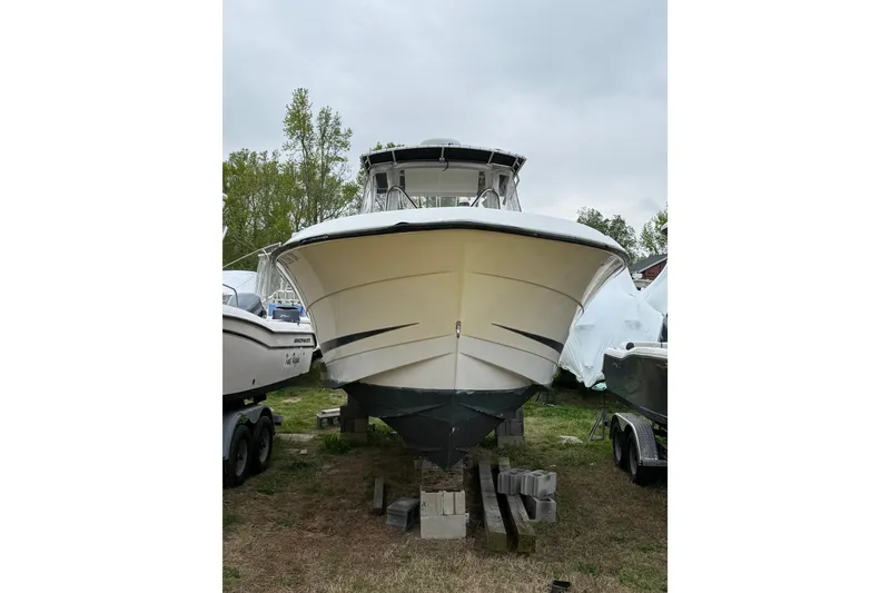 Slide: The Image of 2003 Hydra-Sports Vector 2800 CC boat on land, front view, overcast sky. - 9