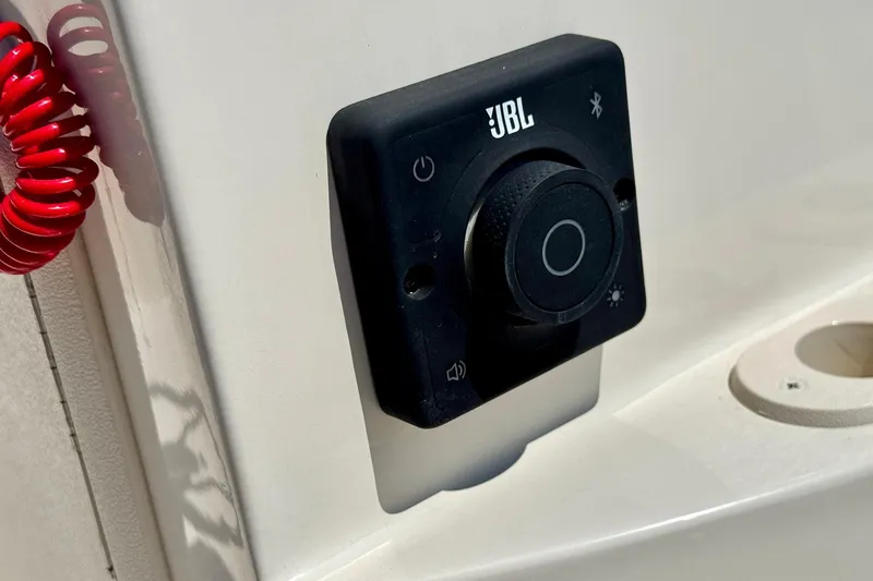Slide: The Image of JBL audio control panel on 2025 Carolina Skiff 178 JLS boat dashboard. - 13