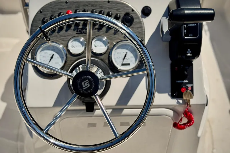Slide: The Image of 2025 Carolina Skiff 178 JLS boat dashboard with steering wheel and gauges. - 14