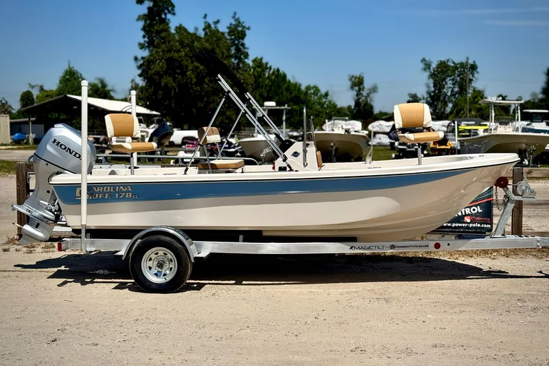 Slide: The Image of 2025 Carolina Skiff 178 JLS boat on trailer, featuring Honda outboard motor. - 2