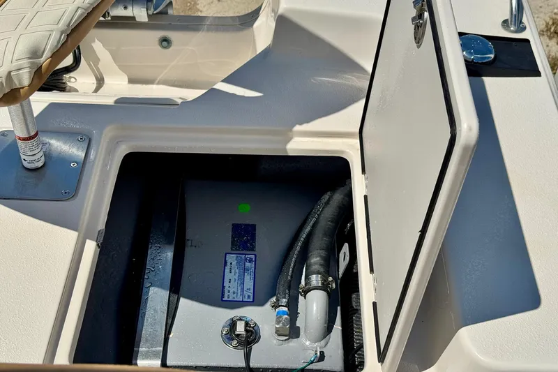 Slide: The Image of Open storage compartment on a 2025 Carolina Skiff 178 JLS boat, revealing internal components. - 7