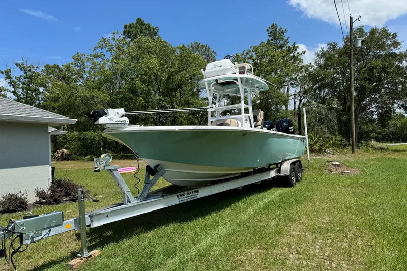 Slide: The Image of 2024 Tidewater 2700 Carolina Bay boat on trailer in grassy yard. - 2