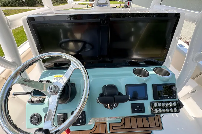 Slide: The Image of 2024 Tidewater 2700 Carolina Bay helm with dual screens and modern controls. - 5