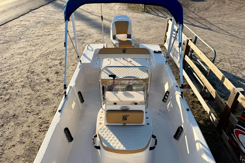 Slide: The Image of 2026 Carolina Skiff 178 JLS boat with blue canopy, beige seating, and spacious deck. - 22