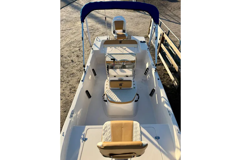 Slide: The Image of 2026 Carolina Skiff 178 JLS boat interior with seating and blue canopy. - 23