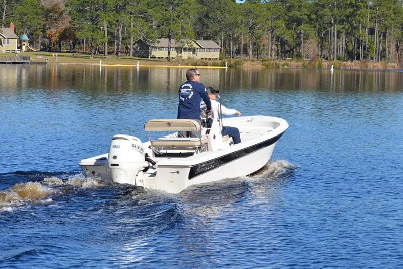 Slide: The Image of Manufacturer Provided Image: 2025 Carolina Skiff 178 JLS boat cruising on a serene lake with lush greenery. - 32