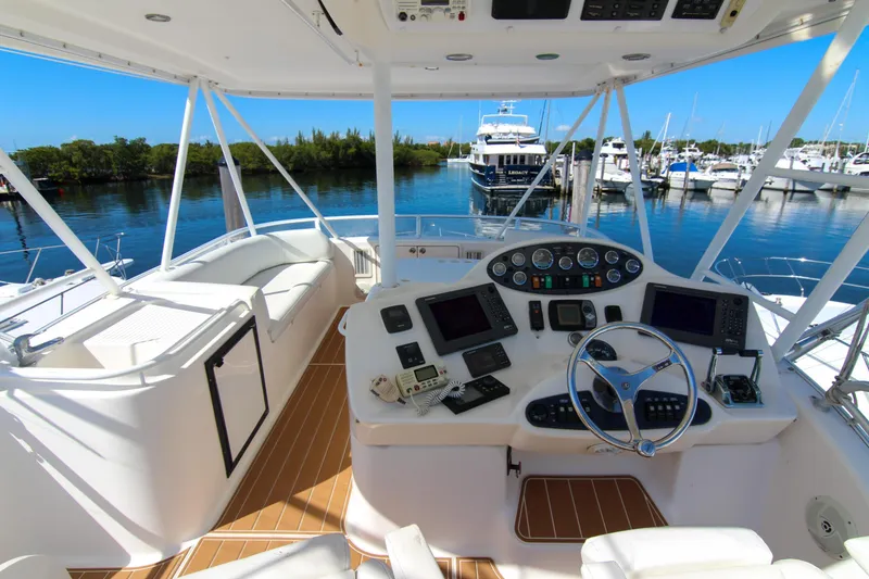 Slide: The Image of 2006 Riviera 47 Open Flybridge Series II yacht helm with marina view. - 10