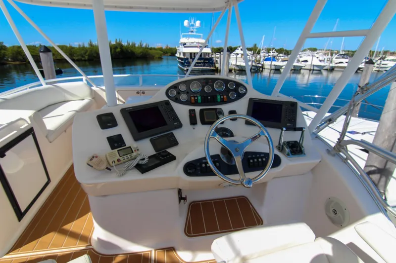 Slide: The Image of Helm of 2006 Riviera 47 Open Flybridge Series II yacht at marina. - 12
