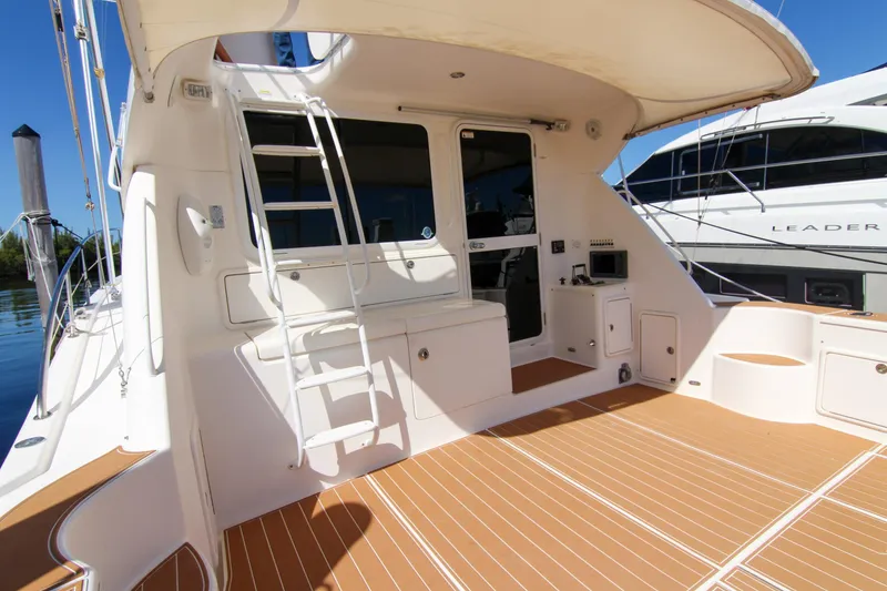 Slide: The Image of 2006 Riviera 47 Open Flybridge Series II yacht deck with ladder and seating area. - 14