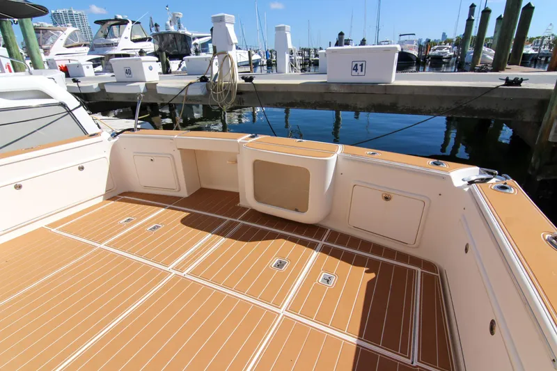 Slide: The Image of 2006 Riviera 47 Open Flybridge Series II yacht deck at marina, featuring teak flooring. - 15