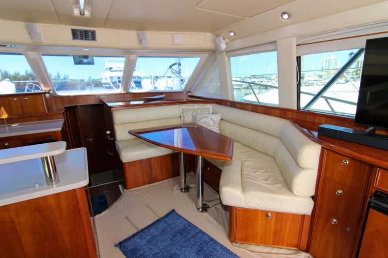 Slide: The Image of Luxurious interior of 2006 Riviera 47 Open Flybridge yacht with leather seating and wooden finishes. - 21