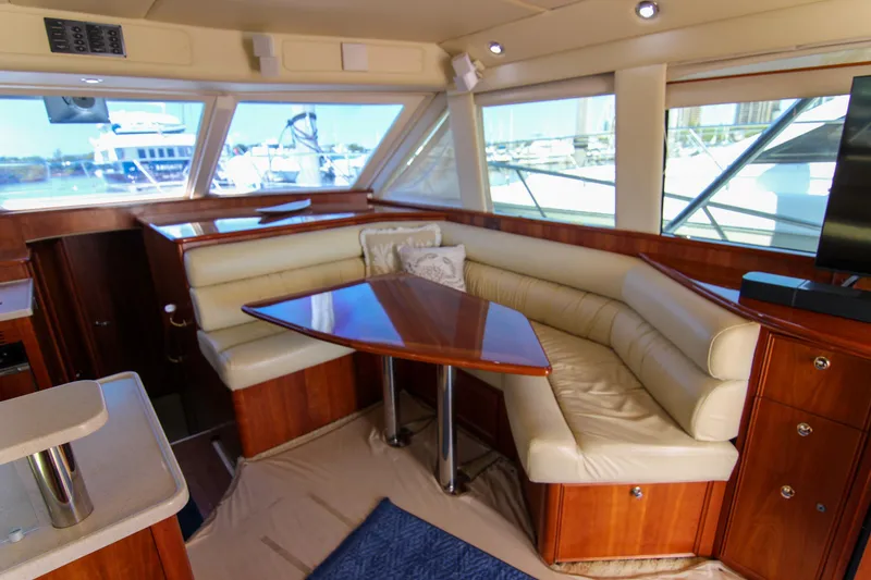 Slide: The Image of Luxurious interior of 2006 Riviera 47 Open Flybridge yacht with leather seating and wooden table. - 27