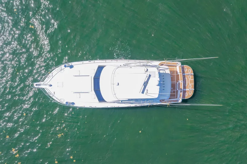 Slide: The Image of Aerial view of 2006 Riviera 47 Open Flybridge Series II yacht on green water. - 47