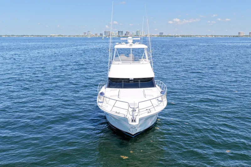 Slide: The Image of 2006 Riviera 47 Open Flybridge Series II yacht on open water, city skyline in background. - 51