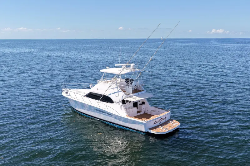 Slide: The Image of 2006 Riviera 47 Open Flybridge Series II yacht on open sea under clear sky. - 57