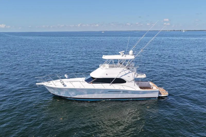 Slide: The Image of 2006 Riviera 47 Open Flybridge Series II yacht on calm blue waters. - 63