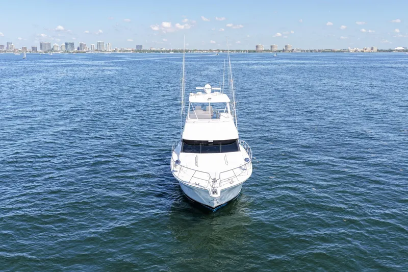 Slide: The Image of 2006 Riviera 47 Open Flybridge Series II yacht on open water with city skyline backdrop. - 64