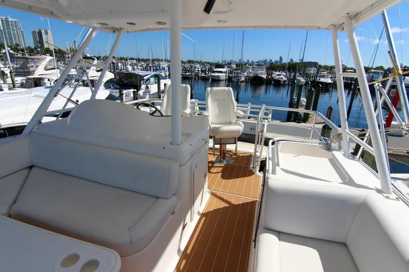 Slide: The Image of 2006 Riviera 47 Open Flybridge Series II yacht interior at marina, featuring seating and helm. - 7