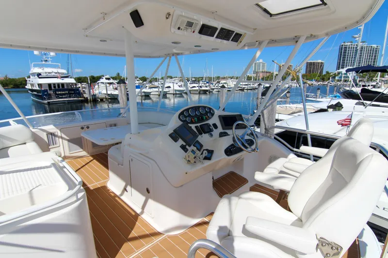 Slide: The Image of 2006 Riviera 47 Open Flybridge Series II yacht helm with marina view. - 9