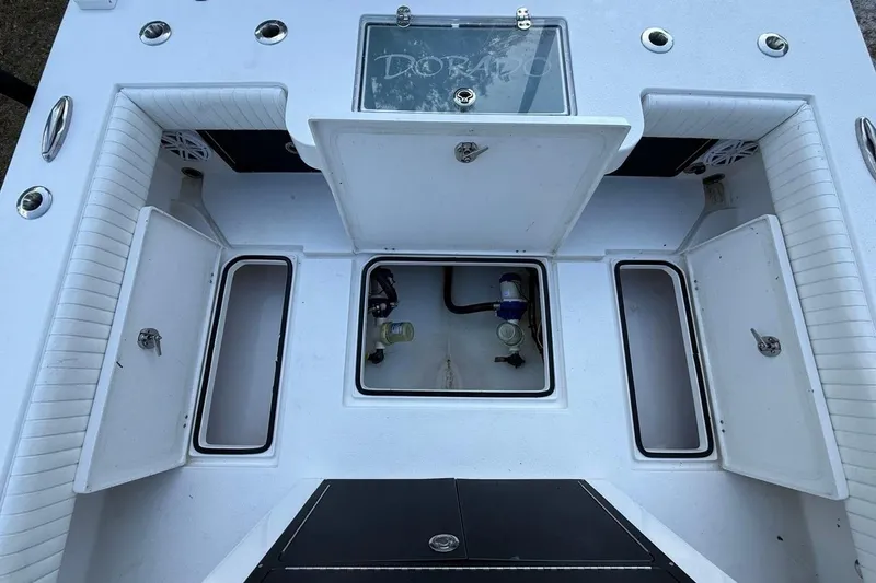Slide: The Image of 2017 Dorado 25 SE boat deck with open storage compartments and seating. - 12