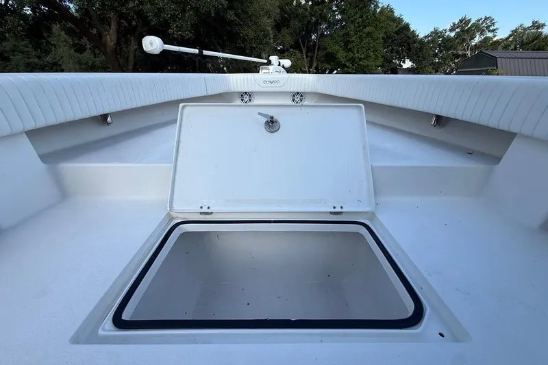 Slide: The Image of Open storage compartment on 2017 Dorado 25 SE boat deck, surrounded by trees. - 22