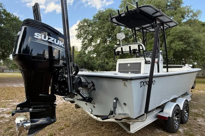 Slide: The Image of 2017 Dorado 25 SE boat with Suzuki outboard motor on a trailer, parked outdoors. - 6