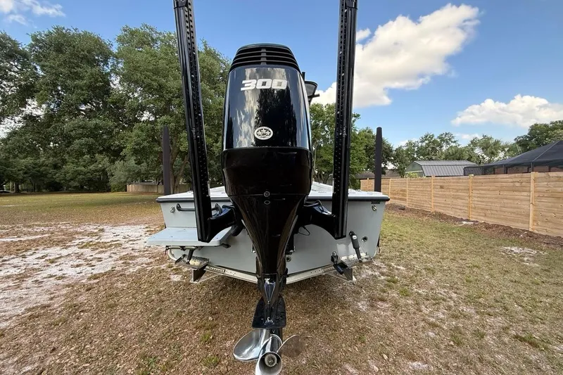 Slide: The Image of 2017 Dorado 25 SE boat with powerful outboard motor, parked on grassy area. - 7