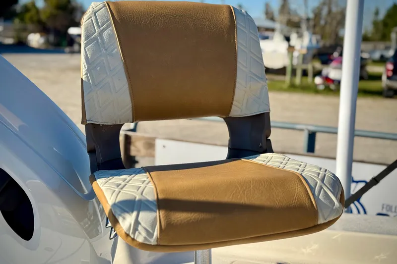 Slide: The Image of 2025 Carolina Skiff 192 JLS boat seat with tan and white upholstery, outdoor setting. - 5