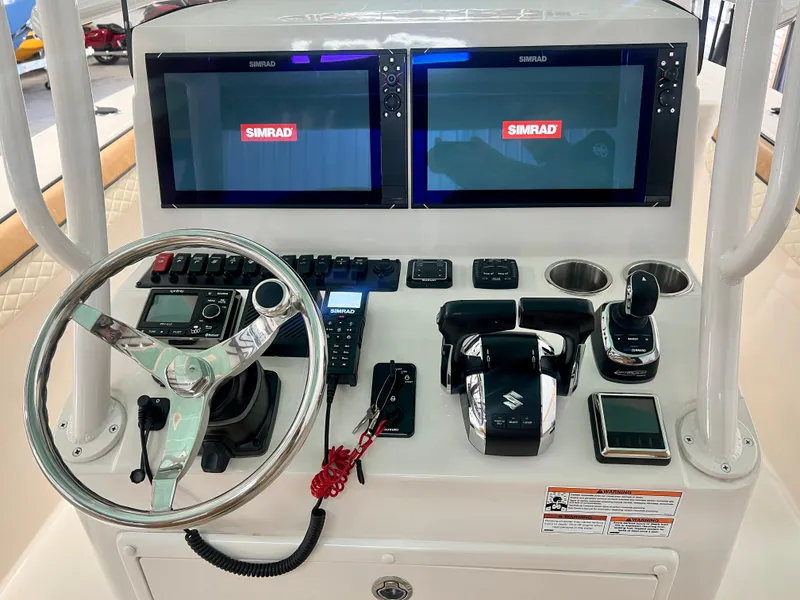 Slide: The Image of 2023 Sea Chaser 30HFC boat dashboard with dual Simrad displays and Suzuki controls. - 13